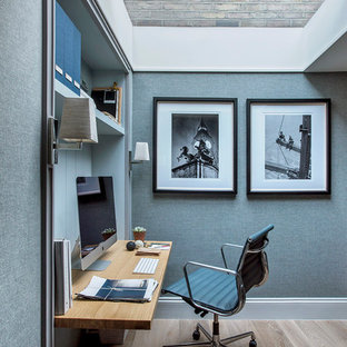 小さいモダンスタイルのおしゃれなホームオフィス・仕事部屋 (青い壁、淡色無垢フローリング、造り付け机、ベージュの床) の写真