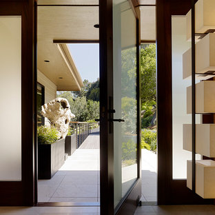 サンフランシスコの小さい回転式ドアコンテンポラリースタイルのおしゃれな玄関ホール (茶色い壁、ガラスドア、ベージュの床) の写真