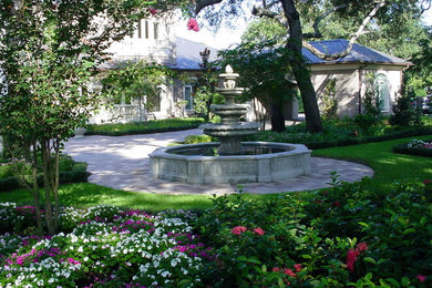Large elegant front yard concrete paver and round pool photo in Tampa