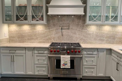 Example of a mid-sized transitional l-shaped porcelain tile and black floor open concept kitchen design in Tampa with a double-bowl sink, shaker cabinets, white cabinets, quartzite countertops, beige backsplash, stone slab backsplash, stainless steel appliances, an island and beige countertops