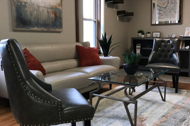 Example of a mid-sized eclectic enclosed medium tone wood floor living room design in Other with beige walls