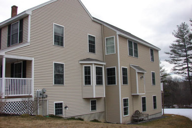 Example of a large beige two-story vinyl and clapboard exterior home design in Portland Maine with a shingle roof