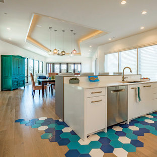 Exemple d'une grande arrière-cuisine linéaire chic avec un évier posé, un placard à porte shaker, des portes de placard bleues, un plan de travail en bois, une crédence blanche, une crédence en carrelage métro, un électroménager en acier inoxydable, un sol en bois brun, aucun îlot, un sol beige et un plan de travail bleu.