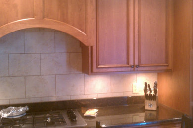 Inspiration for a mid-sized timeless kitchen remodel in Chicago with recessed-panel cabinets, medium tone wood cabinets, granite countertops, beige backsplash and ceramic backsplash
