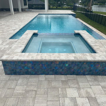 Modern Pool and Raised Spa with Iridescent Glass Tile and Stone Paver Deck