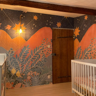 Réalisation d'une petit chambre de bébé neutre avec un mur multicolore, sol en stratifié, un sol beige, un plafond en poutres apparentes et du papier peint.