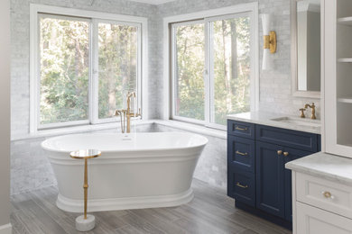 Inspiration for a white tile and marble tile porcelain tile, gray floor and single-sink freestanding bathtub remodel in St Louis with marble countertops and white countertops