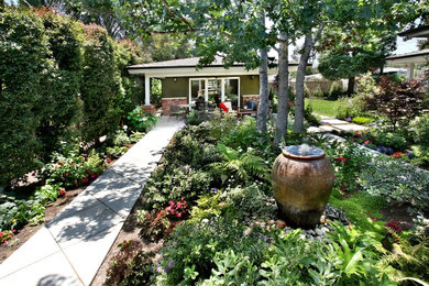 Inspiration for a large traditional partial sun backyard concrete paver landscaping in Orange County.