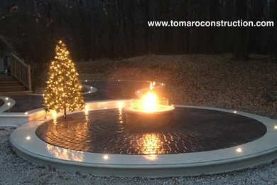 Photo of a large backyard patio in Cleveland with a fire feature, stamped concrete and no cover.