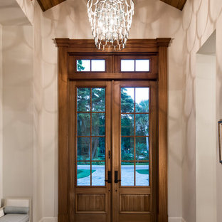 Photo of a country entryway in Miami with white walls, dark hardwood floors, a double front door, a dark wood front door and brown floor.
