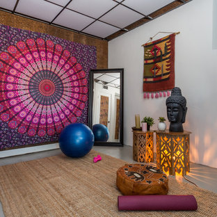 Ispirazione per uno studio yoga etnico con pareti bianche, pavimento in cemento e pavimento grigio