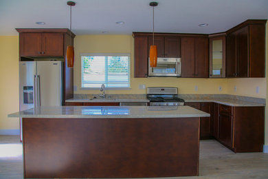 Eat-in kitchen - mid-sized contemporary l-shaped light wood floor and beige floor eat-in kitchen idea in San Francisco with a drop-in sink, raised-panel cabinets, brown cabinets, granite countertops, yellow backsplash, stainless steel appliances, an island and stone tile backsplash
