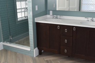 Design ideas for a mid-sized transitional master bathroom in Boston with recessed-panel cabinets, dark wood cabinets, an alcove shower, blue tile, subway tile, blue walls, porcelain floors, an undermount sink, marble benchtops, brown floor and a hinged shower door.