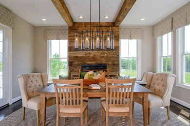 Large country separate dining room in Other with beige walls, medium hardwood floors, a standard fireplace and a wood fireplace surround.
