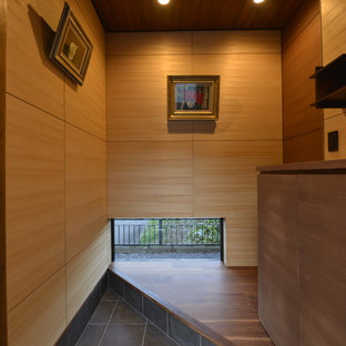 東京23区の和風のおしゃれな玄関 (茶色い壁、黒い床) の写真