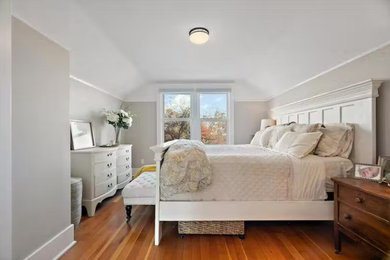 Foto de dormitorio de estilo americano con suelo de madera en tonos medios y suelo naranja