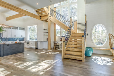 Example of a large beach style wooden u-shaped open and metal railing staircase design in Miami