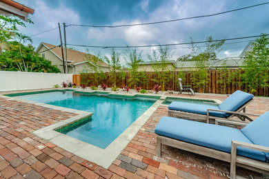 Mid-sized beach style backyard brick and custom-shaped natural hot tub photo in Tampa