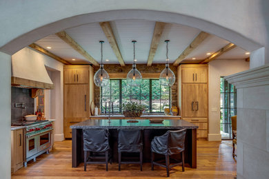 Example of a french country l-shaped kitchen design with an island