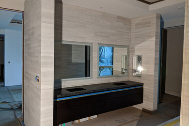Huge trendy master beige tile bathroom photo in Hawaii with flat-panel cabinets, black cabinets and black countertops