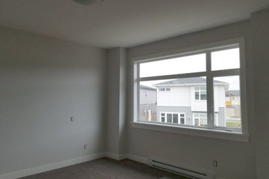 Imagen de dormitorio principal moderno con paredes beige y moqueta