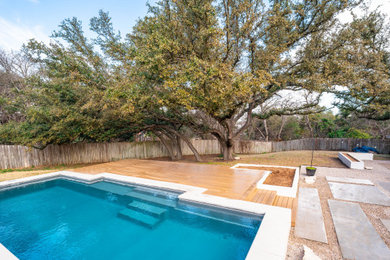 Cette image montre un piscine avec aménagement paysager arrière minimaliste de taille moyenne et sur mesure avec une terrasse en bois.