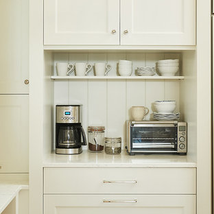 Large traditional kitchen pantry inspiration - Example of a large classic l-shaped medium tone wood floor and brown floor kitchen pantry design in Grand Rapids with recessed-panel cabinets, quartz countertops, white backsplash and an island