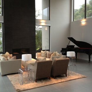 Modern inredning av ett stort allrum med öppen planlösning, med ett musikrum, grå väggar, klinkergolv i keramik, en bred öppen spis och grått golv