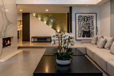 Living room - large contemporary formal and open concept medium tone wood floor and gray floor living room idea in Los Angeles with white walls, a two-sided fireplace, a stone fireplace and no tv