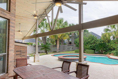 Large trendy backyard concrete patio photo in Houston with a roof extension