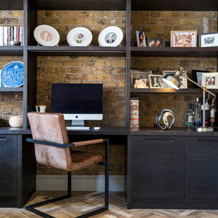 Small urban home office and library in London with beige walls, light hardwood flooring, a built-in desk and brown floors.