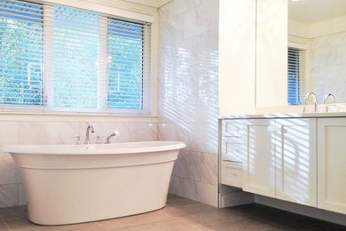 Example of a large classic master gray tile and porcelain tile porcelain tile bathroom design in Vancouver with an undermount sink, shaker cabinets, white cabinets, quartzite countertops and white walls