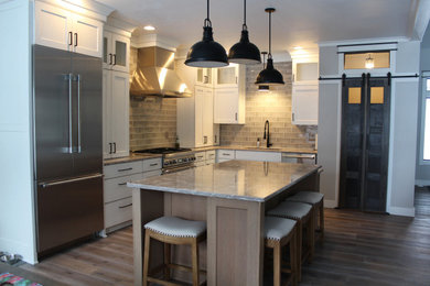Example of a large transitional l-shaped eat-in kitchen design in Other with recessed-panel cabinets, white cabinets, quartz countertops and an island