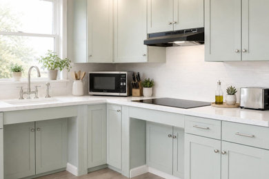 Example of a mid-sized country l-shaped light wood floor and beige floor eat-in kitchen design in New York with an undermount sink, shaker cabinets, green cabinets, quartz countertops, white backsplash, ceramic backsplash, stainless steel appliances, no island and white countertops