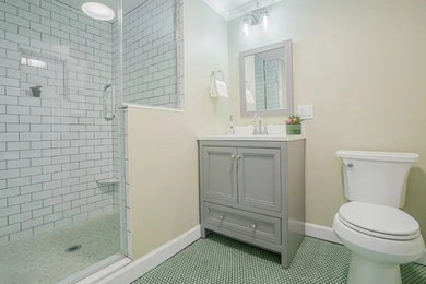 Mid-sized trendy white tile and subway tile ceramic tile, green floor, single-sink and vaulted ceiling bathroom photo in New York with beaded inset cabinets, gray cabinets, a two-piece toilet, yellow walls, an undermount sink, quartz countertops, a hinged shower door, white countertops, a niche and a freestanding vanity