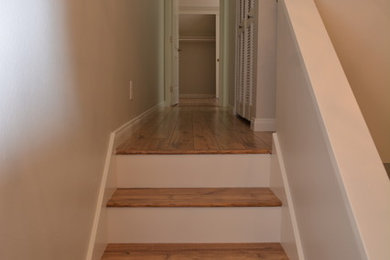 Example of a wooden u-shaped staircase design in Orange County with painted risers