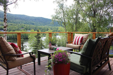 Example of a large mountain style backyard deck design in Other with no cover