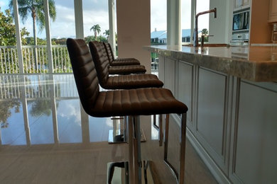 Mid-sized transitional galley eat-in kitchen photo in Miami with raised-panel cabinets, white cabinets, granite countertops, gray backsplash, stainless steel appliances and an island