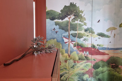 Cette image montre un petit couloir design avec un mur rose, sol en stratifié, un sol marron et du papier peint.