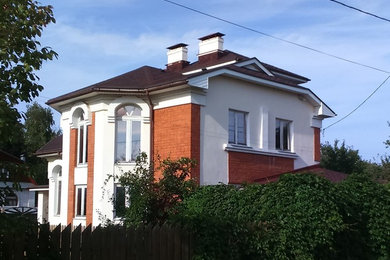 Imagen de fachada de casa multicolor clásica renovada grande a niveles con revestimiento de estuco, tejado a la holandesa y tejado de teja de madera