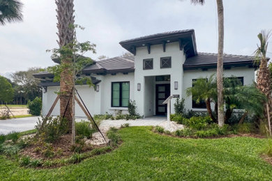 Example of a mid-sized tuscan white one-story stucco house exterior design in Other with a tile roof and a brown roof
