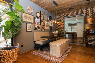 Inspiration for a mid-sized industrial brown floor and dark wood floor kitchen/dining room combo remodel in Dallas with multicolored walls and no fireplace