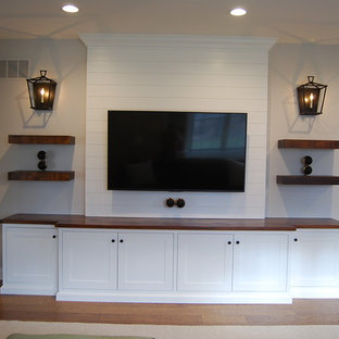 This is an example of a small country home cinema in Philadelphia with grey walls, dark hardwood flooring, a wall mounted tv and brown floors.