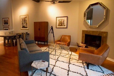 Inspiration for a mid-sized eclectic loft-style medium tone wood floor and brown floor living room remodel in Tampa with gray walls, a standard fireplace, a stone fireplace and no tv