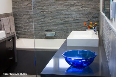 Mid-sized modern master bathroom in Los Angeles with a drop-in sink, dark wood cabinets, engineered quartz benchtops, a drop-in tub, a one-piece toilet, gray tile, porcelain tile, white walls and an open shower.