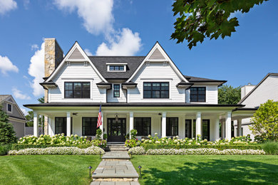 Inspiration for a mid-sized cottage white two-story house exterior remodel in Detroit with a hip roof and a shingle roof