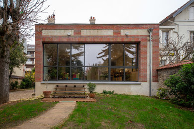 Exemple d'une façade de maison marron tendance en brique de taille moyenne et de plain-pied avec un toit plat.