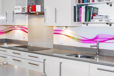 Example of a large minimalist kitchen design in Houston with multicolored backsplash, glass sheet backsplash and stainless steel appliances