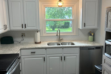 Inspiration for a mid-sized modern l-shaped enclosed kitchen remodel in Other with white cabinets, quartz countertops and white backsplash