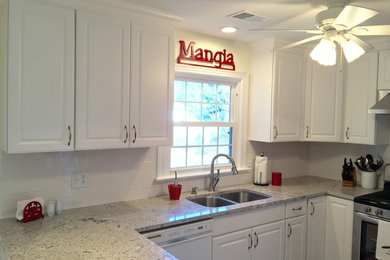 Inspiration for a mid-sized transitional u-shaped porcelain tile enclosed kitchen remodel in Other with an undermount sink, raised-panel cabinets, white cabinets, granite countertops, white backsplash, ceramic backsplash, stainless steel appliances and a peninsula